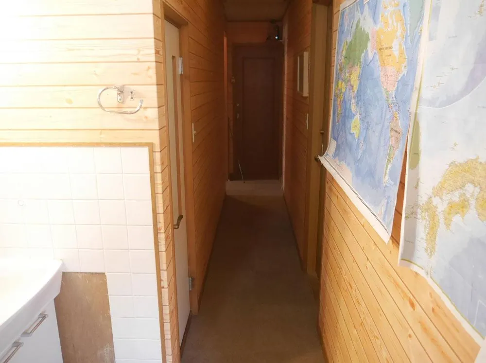 Hallway with world maps and a washbasin at Rozan