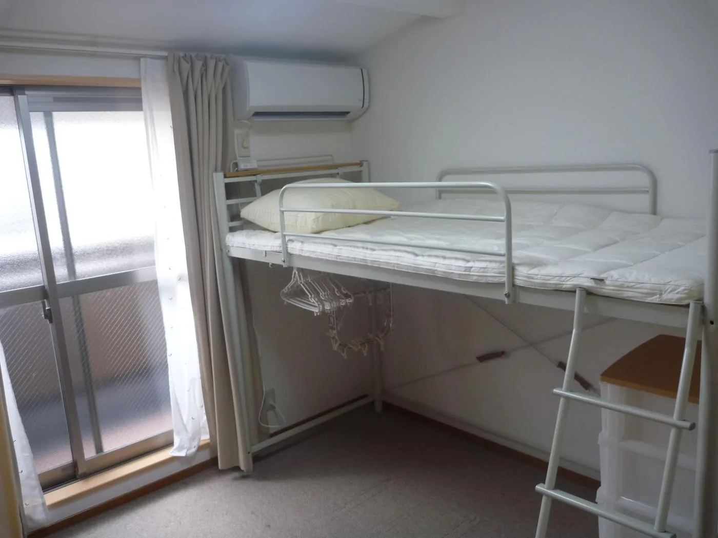 Private room with a loft bed and balcony window at Tate